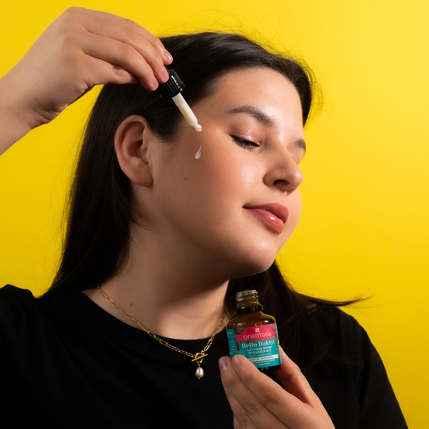 Dziewczyna z ładną cerą aplikująca z pipetki serum Hello Daktyl